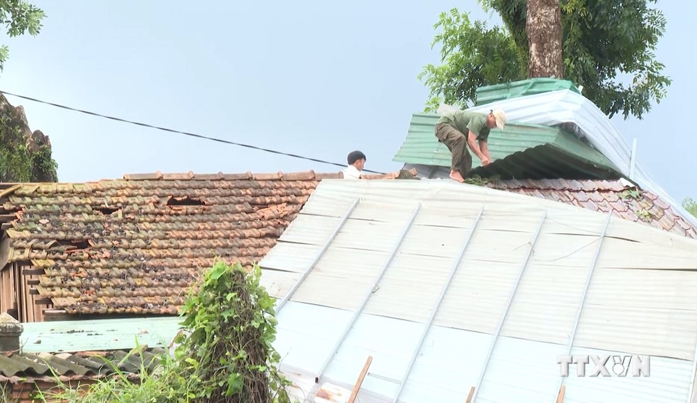 Chính quyền địa phương hỗ trợ người dân sửa lại các mái nhà bị hư hỏng. Ảnh: TTXVN phát