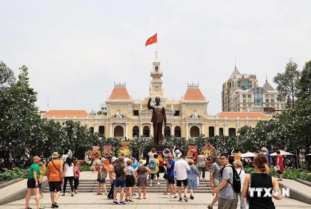 Đoàn khách quốc tế tham quan Tượng đài Chủ tịch Hồ Chí Minh trước Trụ sở HĐND, UBND Thành phố. Ảnh: Hồng Đạt - TTXVN