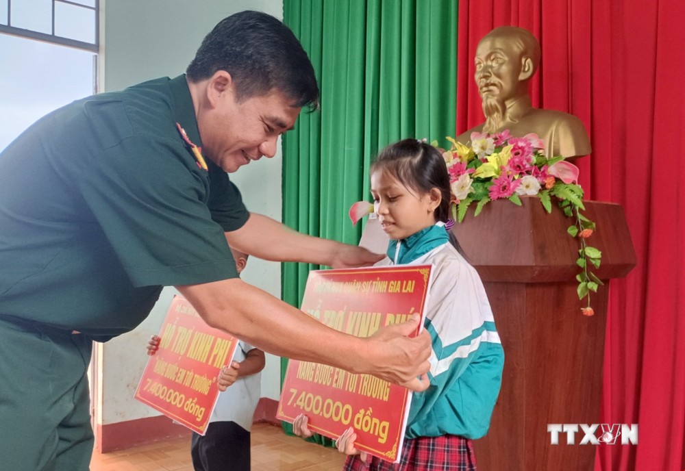 Đại tá Ksơr Lành, Phó Chính ủy Bộ Chỉ huy quân sự tỉnh Gia Lai, tặng quà cho các em học sinh tại xã Ia Chía, huyện Ia Grai, tỉnh Gia Lai. Ảnh: Hồng Điệp - TTXVN