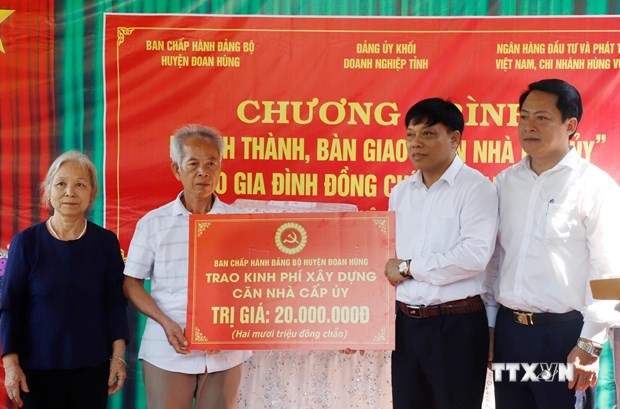 Lãnh đạo huyện Đoan Hùng trao tượng trưng số tiền hỗ trợ xây dựng căn nhà cấp ủy và tặng quà cho gia đình đảng viên. Ảnh: Trung Kiên - TTXVN