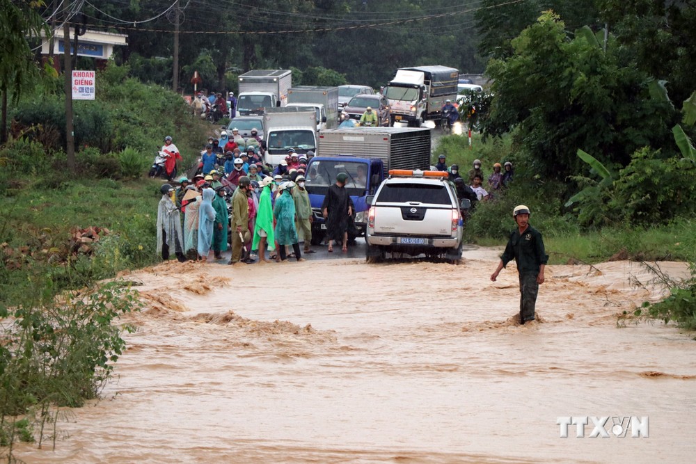 Mưa lớn làm Tỉnh lộ 675 đi từ huyện Sa Thầy về thành phố Kon Tum (tỉnh Kon Tum) bị ngập khiến người và phương tiện không thể lưu thông. Ảnh: Cao Nguyên -TTXVN