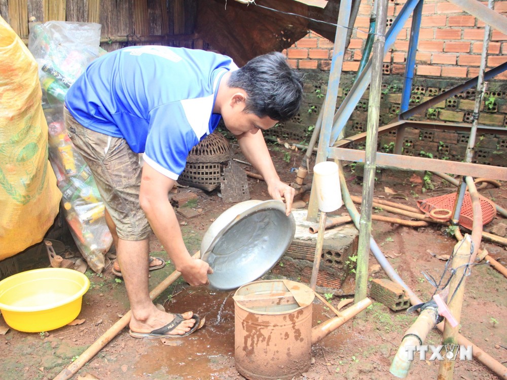 Người dân huyện biên giới Bù Gia Mâp chủ động xử lý dụng cụ chứa, đọng nước, không để muỗi sinh sản. Ảnh: K GỬIH - TTXVN