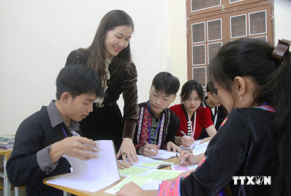 Cô giáo Nguyễn Thị Mai hướng dẫn học sinh làm bài tập thực hành. Ảnh: Phan Quân - TTXVN