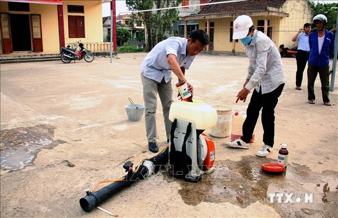 Cán bộ Trung tâm y tế huyện Quảng Ninh (Quảng Bình) pha thuốc phun hóa chất diệt muỗi tại xã Võ Ninh. Ảnh: Văn Tý-TTXVN