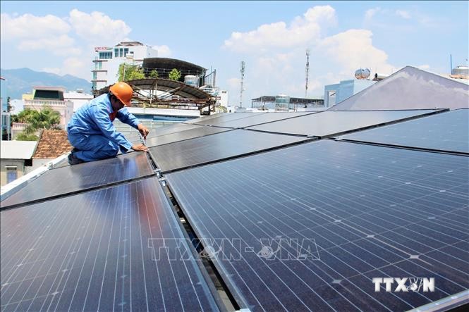 Lắp đặt tấm pin mặt trời trên mái nhà tại một hộ dân Ảnh: Tiên Minh - TTXVN