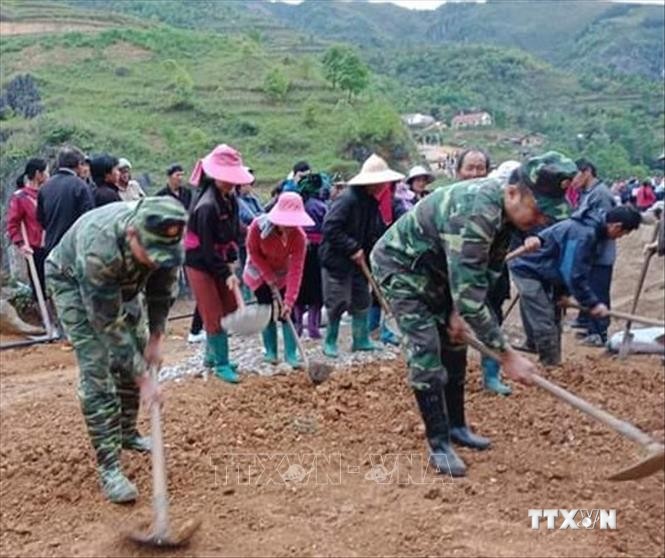 Cán bộ, chiến sĩ Đồn biên phòng Nghĩa Thuận giúp dân làm đường, xây dựng nông thôn mới. Ảnh: Nguyễn Chiến - TTXVN