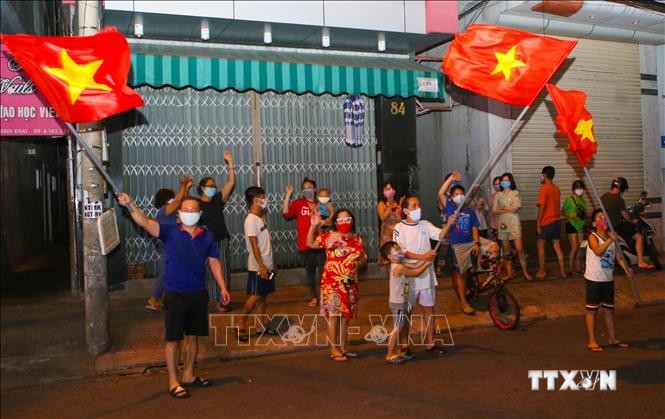 Người dân ở trên tuyến đường Nguyễn Thị Minh Khai vui mừng sau khi hoàn thành cách ly 14 ngày trong khu vực phong tỏa. Ảnh: Trần Lê Lâm - TTXVN