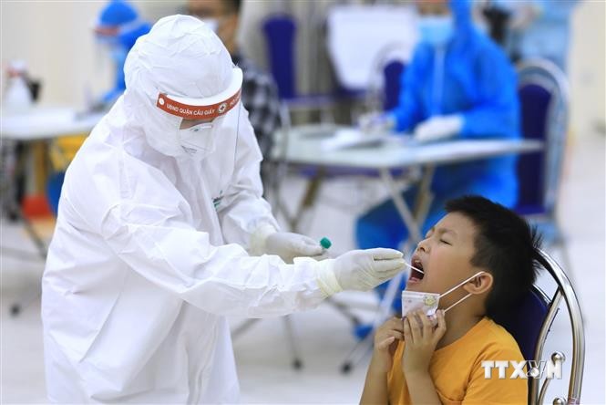 Nhân viên y tế tiến hành lấy mẫu dịch hầu họng để xét nghiệm bằng phương pháp RT-PCR của người dân từ Đà Nẵng trở về. Ảnh: Thành Đạt - TTXVN