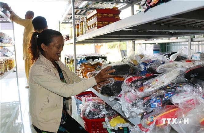 Với phiếu 200 nghìn đồng, bà Nguyễn Thị Hiệp có thể "mua" các nhu yếu phẩm cần thiết tại “Cửa hàng 0 đồng”. Ảnh: Chương Đài - TTXVN