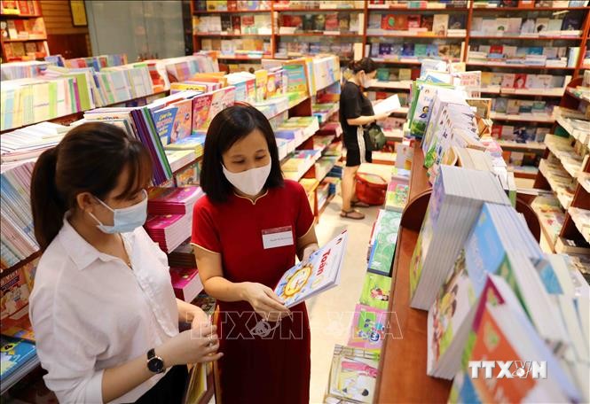 Phụ huynh chọn mua SGK tại hệ thống cửa hàng ADC book của Nhà xuất bản Giáo dục Việt Nam. Ảnh: Thanh Tùng – TTXVN