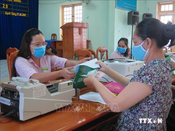 Người dân phường Quyết Thắng, thành phố Kon Tum làm thủ tục nhận tiền vay vốn tín dụng chính sách. Ảnh: Dư Toán – TTXVN