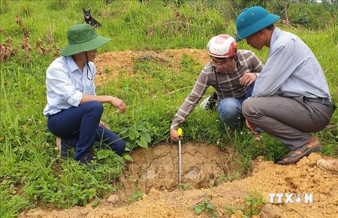 Cán bộ nông nghiệp xã Nậm Manh, huyện Nậm Nhùn, hướng dẫn bà con dân tộc trên địa bàn đào hố trồng cây xoài Đài Loan đúng kỹ thuật. Ảnh: Việt Hoàng - TTXVN