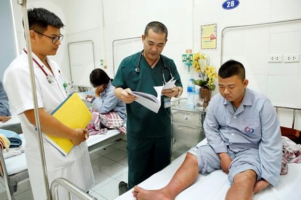 Bác sỹ kiểm tra sức khỏe và hội chẩn điều trị cho người bệnh mắc sốt xuất huyết. Ảnh: Dương Ngọc/TTXVN