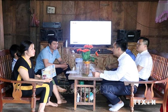 Cán bộ bảo hiểm xã hội huyện Thuận Châu đến từng nhà để tuyên truyền về lợi ích của bảo hiểm y tế học sinh, sinh viên. Ảnh: Hữu Quyết - TTXVN