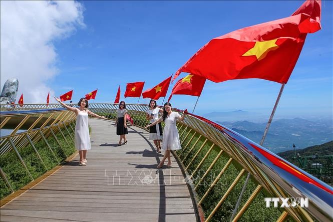 Đà Nẵng: Cầu Vàng rực rỡ cờ Tổ quốc đón du khách sau dịch COVID-19. Ảnh: Trần Lê Lâm - TTXVN