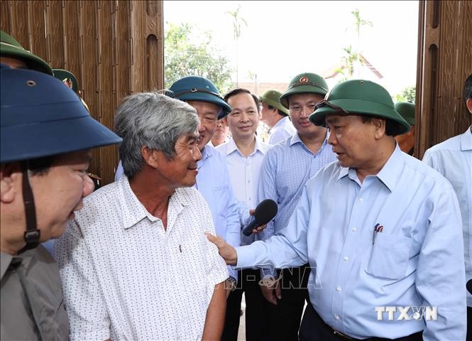 Thủ tướng Nguyễn Xuân Phúc đến thăm hỏi ông Cao Văn Phụng, tại thôn An Hà 1, xã Nghĩa Trung, huyện Tư Nghĩa. Ảnh: Thống Nhất – TTXVN