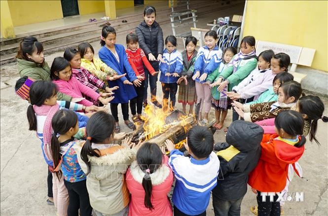 Cô và trò Trường Phổ thông Dân tộc Bán trú Tiểu học Leng Su Sìn (huyện Mường Nhé) đốt lửa sưởi ấm. Ảnh: Xuân Tư – TTXVN