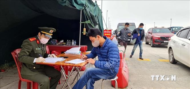 Lực lượng chức năng làm nhiệm vụ hướng dẫn, phân luồng giao thông, khai báo y tế tại chốt trạm cầu Bạch Đằng, thị xã Quảng Yên, tỉnh  Quảng Ninh. Ảnh: TTXVN