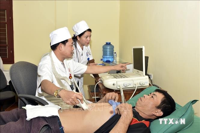 Bác sĩ trẻ tại Bệnh viện Đa khoa huyện Sốp Cộp, tỉnh Sơn La ứng dụng kỹ thuật mới để thăm khám cho bệnh nhân. Ảnh: Hữu Quyết - TTXVN