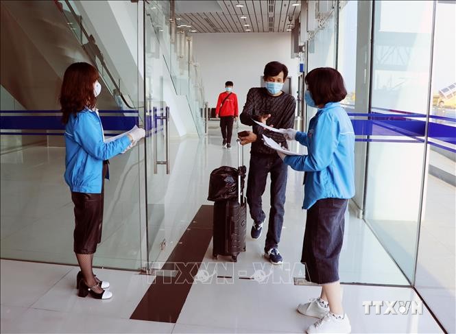 Lực lượng thanh niên tình nguyện hỗ trợ hành khách khai báo thông tin y tế. Ảnh: Hoàng Ngọc - TTXVN