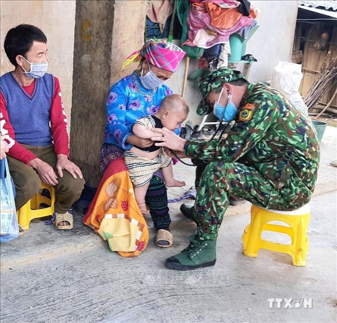 Trung tá Nguyễn Đức Tám khám bệnh cho dân bản. Ảnh: Hồng Ninh - TTXVN