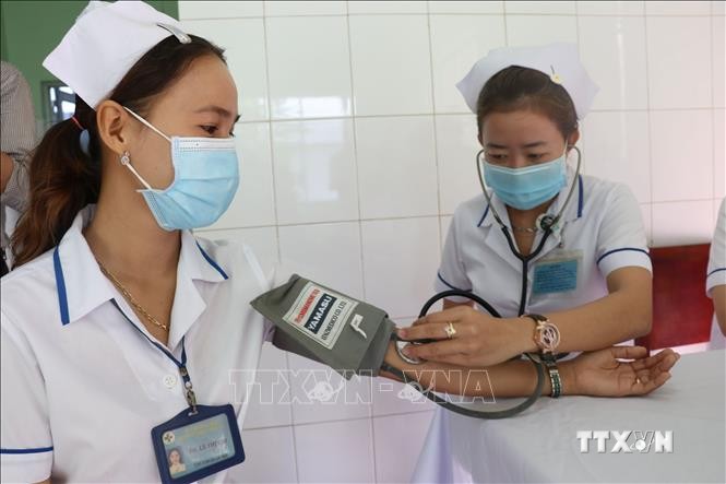 Kiểm tra sức khỏe cho nhân viên y tế trước khi tiêm tại tỉnh Đồng Tháp. Ảnh: Nguyễn Văn Trí - TTXVN