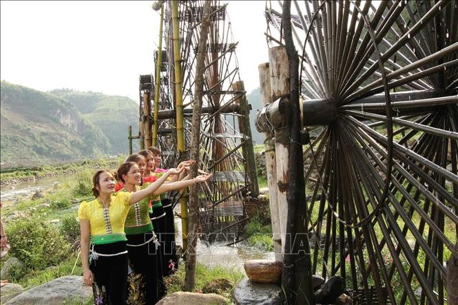 Các cô gái dân tộc Thái bên những guồng nước ở xã Ngọc Chiến, huyện Mường La, tỉnh Sơn La. Ảnh: Nguyễn Cường – TTXVN