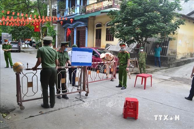Các lực lượng triển khai rào chắn phong tỏa tạm thời 1 đoạn của tuyến đường Thanh niên, thuộc phường Hồng Hà, thành phố Yên Bái. Ảnh: Tuấn Anh - TTXVN