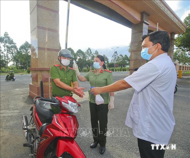 Đo thân nhiệt, rửa tay sát khuẩn phòng chống COVID - 19 tại điểm bỏ phiếu thuộc khu vực bầu cử số 3, phường V, thành phố Vị Thanh, sáng 21/5. Ảnh: Duy Khương - TTXVN