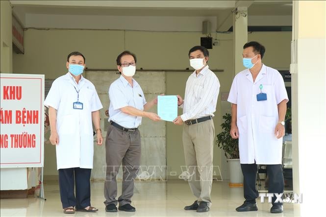 Đại diện ngành Y tế Đắk Lắk trao giấy xuất viện cho bệnh nhân 3836. Ảnh: Tuấn Anh – TTXVN