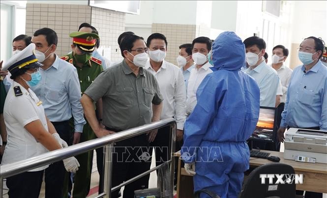 Thủ tướng Phạm Minh Chính thăm hỏi, động viên các đơn vị làm nhiệm vụ tại Trạm liên hợp cửa khẩu quốc tế Mộc Bài. Ảnh: Lê Đức Hoảnh - TTXVN
