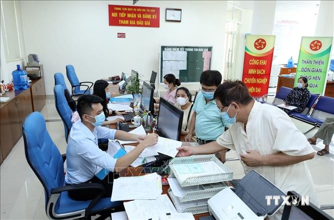Hướng dẫn người dân khai hồ sơ tại Trung tâm Phục vụ hành chính công tỉnh Lạng Sơn. Ảnh: Anh Tuấn - TTXVN
