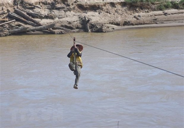 Người dân liều mình đu dây qua sông Pô Kô. Ảnh: Khoa Chương - TTXVN

