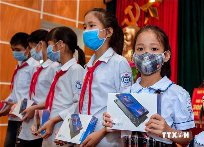 Các em học sinh huyện Ba Vì nhận những chiếc máy tính bảng từ các nhà hảo tâm. Ảnh: Trần Việt - TTXVN
