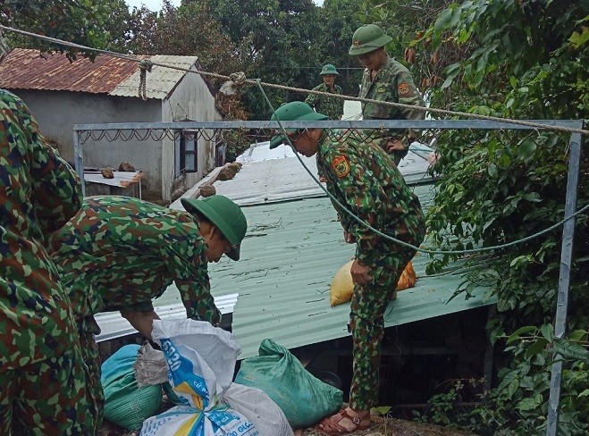 Cán bộ chiến sĩ Đồn Biên phòng Cù Lao Chàm giúp người dân xã đảo Tân Hiệp, thành phố Hội An chèn chống nhà cửa. Ảnh: TTXVN
