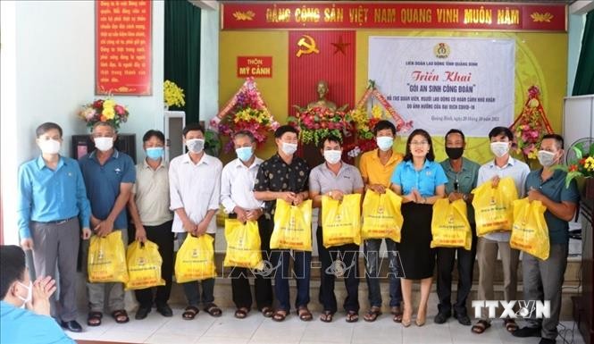 Các đoàn viên, người lao động trên địa bàn tỉnh Quảng Bình phấn khởi khi nhận các túi quà hỗ trợ từ "Gói an sinh Công đoàn". Ảnh: TTXVN phát
