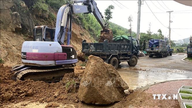 Phương tiện, cơ giới giải tỏa đất đá đổ xuống mặt đường  ở tỉnh Bình Định. Ảnh: Tường Quân - TTXVN
