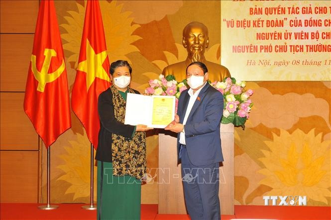 Nguyên Phó Chủ tịch thường trực Quốc hội Tòng Thị Phóng tiếp nhận Giấy chứng nhận đăng ký bản quyền tác giả. Ảnh: Minh Đức - TTXVN
