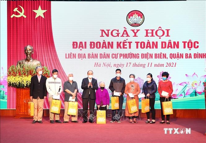 Chủ tịch nước Nguyễn Xuân Phúc trao tặng quà cho 8 hộ gia đình có hoàn cảnh khó khăn tại phường Điện Biên, quận Ba Đình. Ảnh: Phạm Kiên - TTXVN
