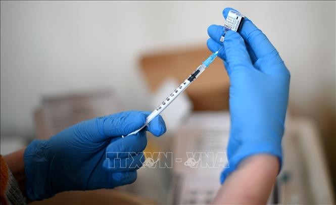 Nhân viên y tế tiêm vaccine ngừa COVID-19 của hãng Pfizer/BioNTech tại London, Anh. Ảnh: AFP/TTXVN