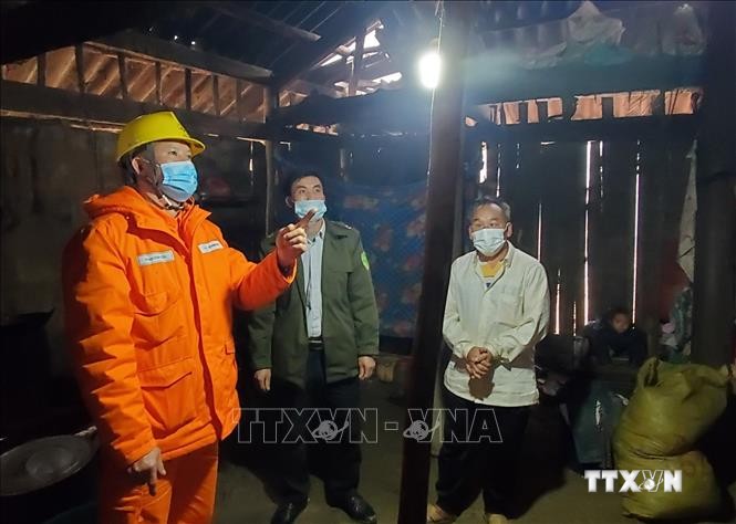 Công nhân Điện lực Mai Sơn, tỉnh Sơn La hướng dẫn người dân xã Chiềng Kheo sử dụng điện an toàn. Ảnh: TTXVN phát
