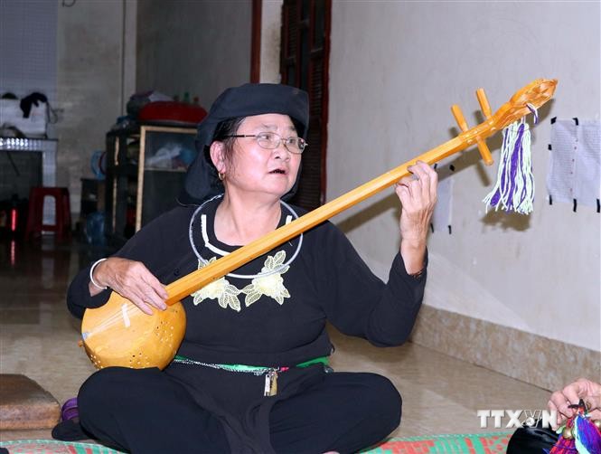 Bà Hà Thị Mỵ (giữa) cùng các thành viên Câu lạc bộ Văn nghệ dân tộc hát Then đàn tính do bà làm Chủ nhiệm tập các bài hát Then do chính bà sáng tác để chuẩn bị biểu diễn. Ảnh: Vũ Quang Đán
