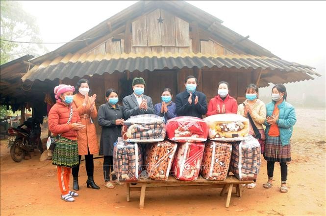 Trao quà cho các nhân dân, hội viên phụ nữ có hoàn cảnh khó khăn xã Phiêng Pằn, huyện Mai Sơn. Ảnh: Quang Quyết - TTXVN