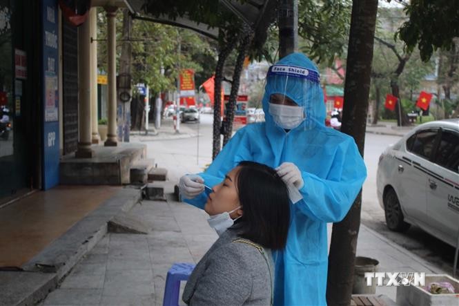 Nhân viên y tế lấy mẫu xét nghiệm COVID-19 cho người dân thành phố Thanh Hóa trong ngày mùng 5 tết Nguyên đán 2022. Ảnh: Nguyễn Nam-TTXVN
