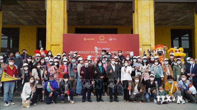 Các hành khách chụp ảnh lưu niệm với lãnh đạo tỉnh Quảng Ninh. Ảnh: TTXVN phát

