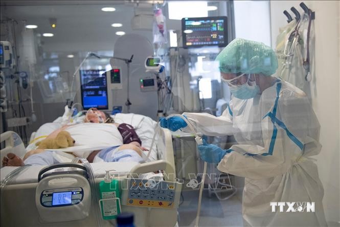 Nhân viên y tế điều trị cho bệnh nhân COVID-19 tại Barcelona, Tây Ban Nha. Ảnh: AFP/ TTXVN
