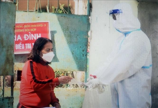 Nhân viên y tế hỗ trợ người nhiễm COVID-19 thể nhẹ tại thành phố Vĩnh Yên. Ảnh: TTXVN phát