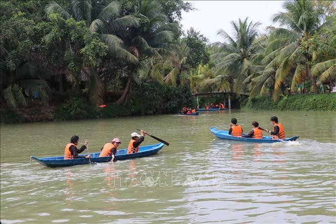 Du khách đến từ Lâm Đồng hào hứng trong các hoạt động chèo xuồng trên sông tại khu du lịch sinh thái Lan Vương, thành phố Bến Tre, tỉnh Bến Tre. Ảnh: Chương Đài - TTXVN