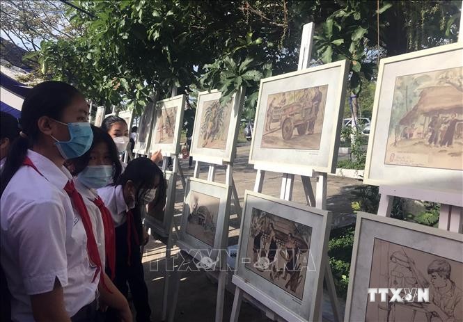 Học sinh xem triển lãm tranh lưu động “Ký họa chiến trường Khu V” sau lễ khai mạc. Ảnh: TTXVN phát
