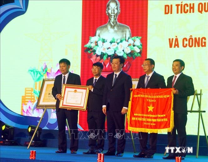 Lãnh đạo Huyện ủy, UBND huyện Nghi Lộc đón nhận Cờ Thi đua của Thủ tướng Chính phủ và Bằng Chứng nhận huyện đạt chuẩn nông thôn mới. Ảnh: Tá Chuyên - TTXVN
